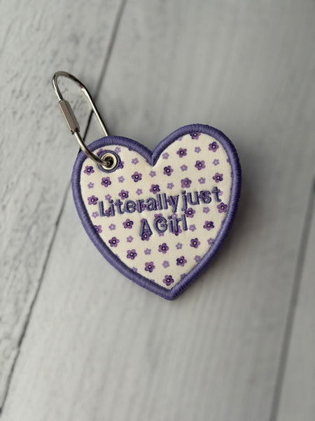 Custom embroidered heart bag tag with “Literally just a girl”